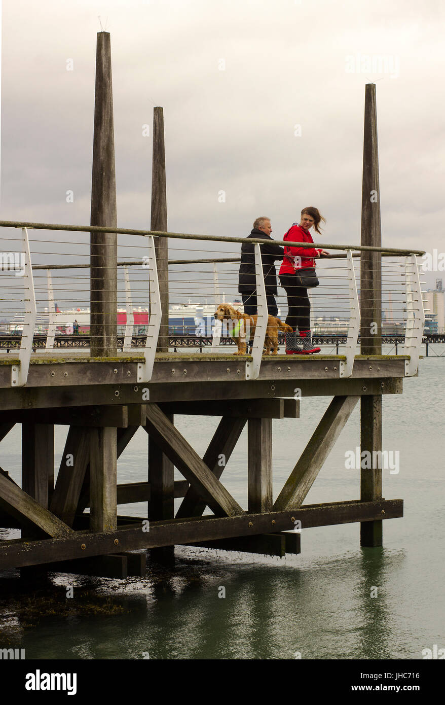 Les vacanciers et leur chien sur la plate-forme panoramique donnant sur le quai de Southampton Water occupé de Hythe dans le Hampshire, sur la côte sud de l'Angleterre Banque D'Images