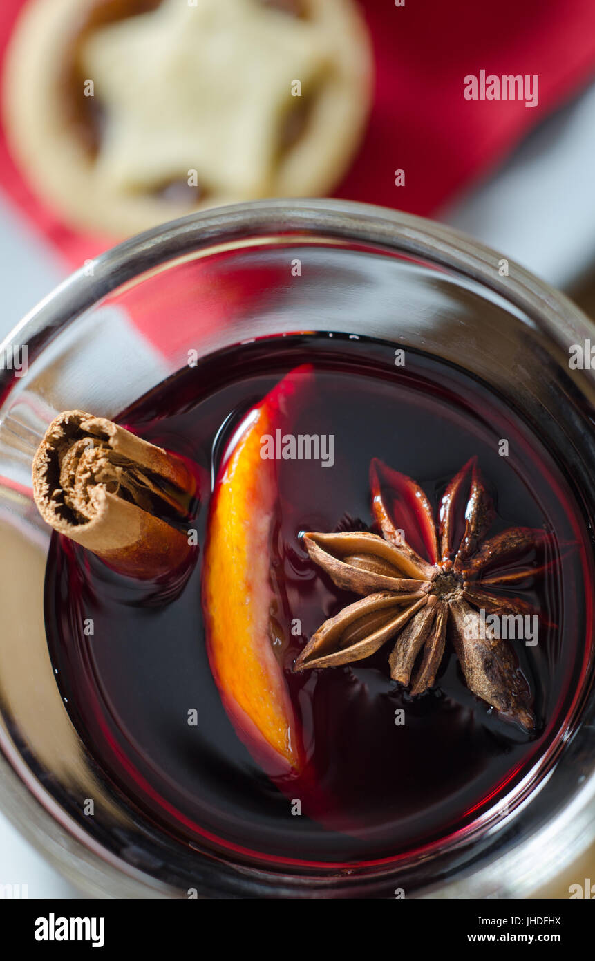 Passage près d'un verre de vin chaud épicé avec l'étoile de Noël en tête mince pie sur red serviette dans l'arrière-plan flou. Banque D'Images