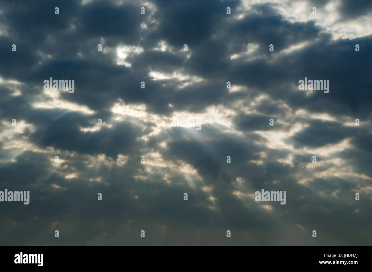 Menaçant, inquiétant ciel gris foncé avec quelques rayons de soleil blanc brillant à travers une lacune dans l'amour les nuages. Banque D'Images