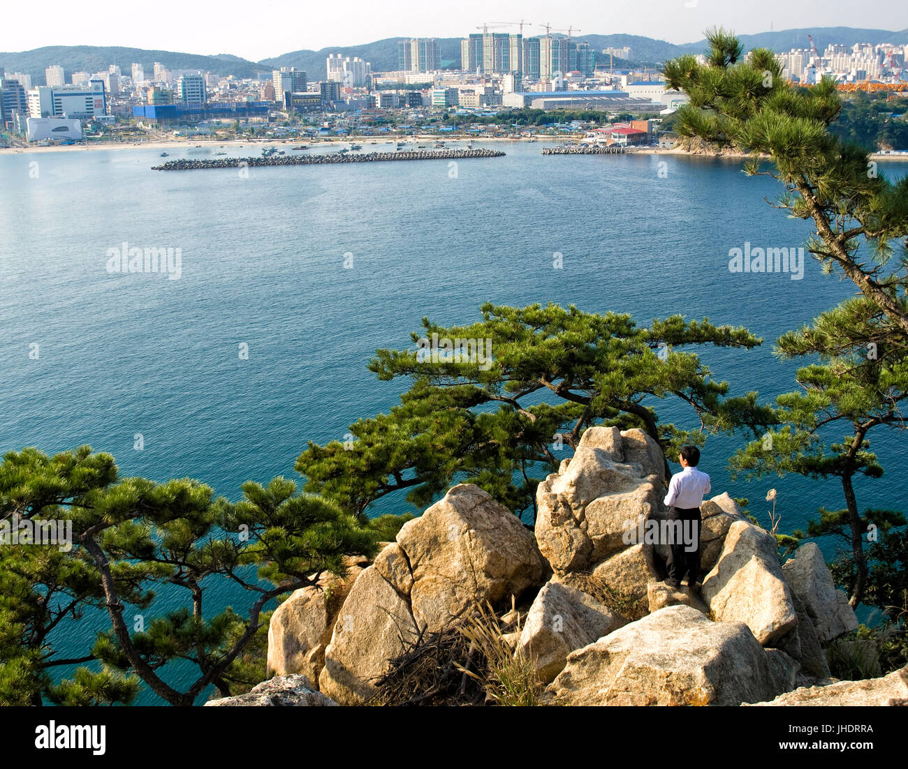 L'homme coréen debout sur les rochers à la recherche à vue sur la ville à Ulsan, Corée du Sud Banque D'Images