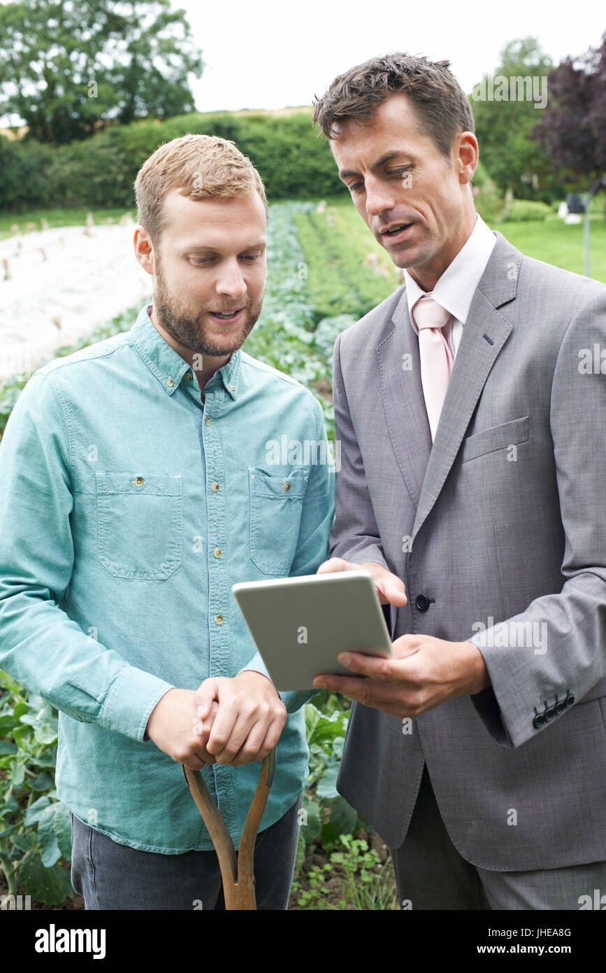 Businessman Using Digital Tablet Au cours de réunion avec Farmer in Field Banque D'Images