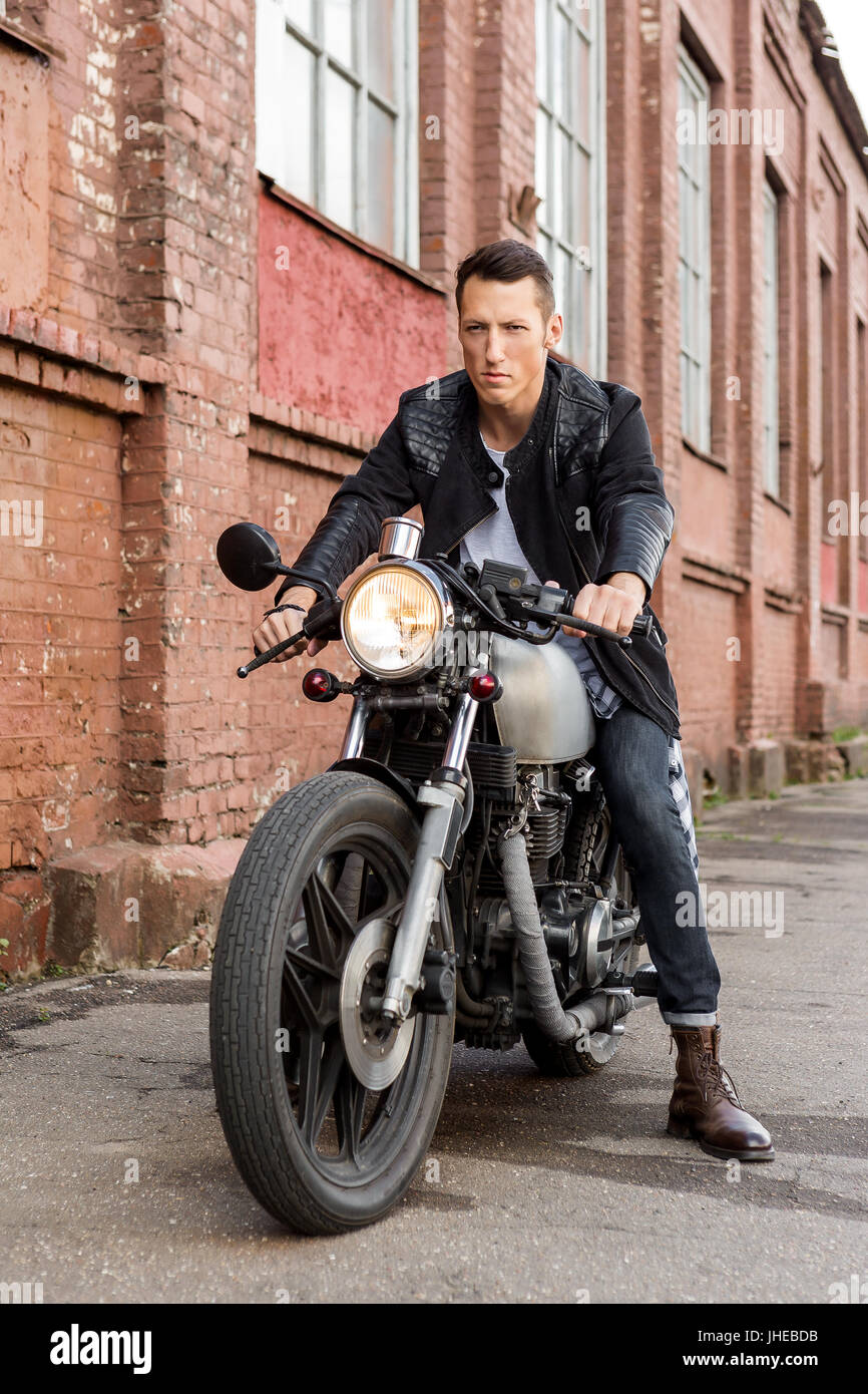 Beau rider biker type en blouson de cuir s asseoir sur un style classique moto cafe racer et pret pour les longs parcours. En fait sur commande de velo vintage garage. Bru Photo