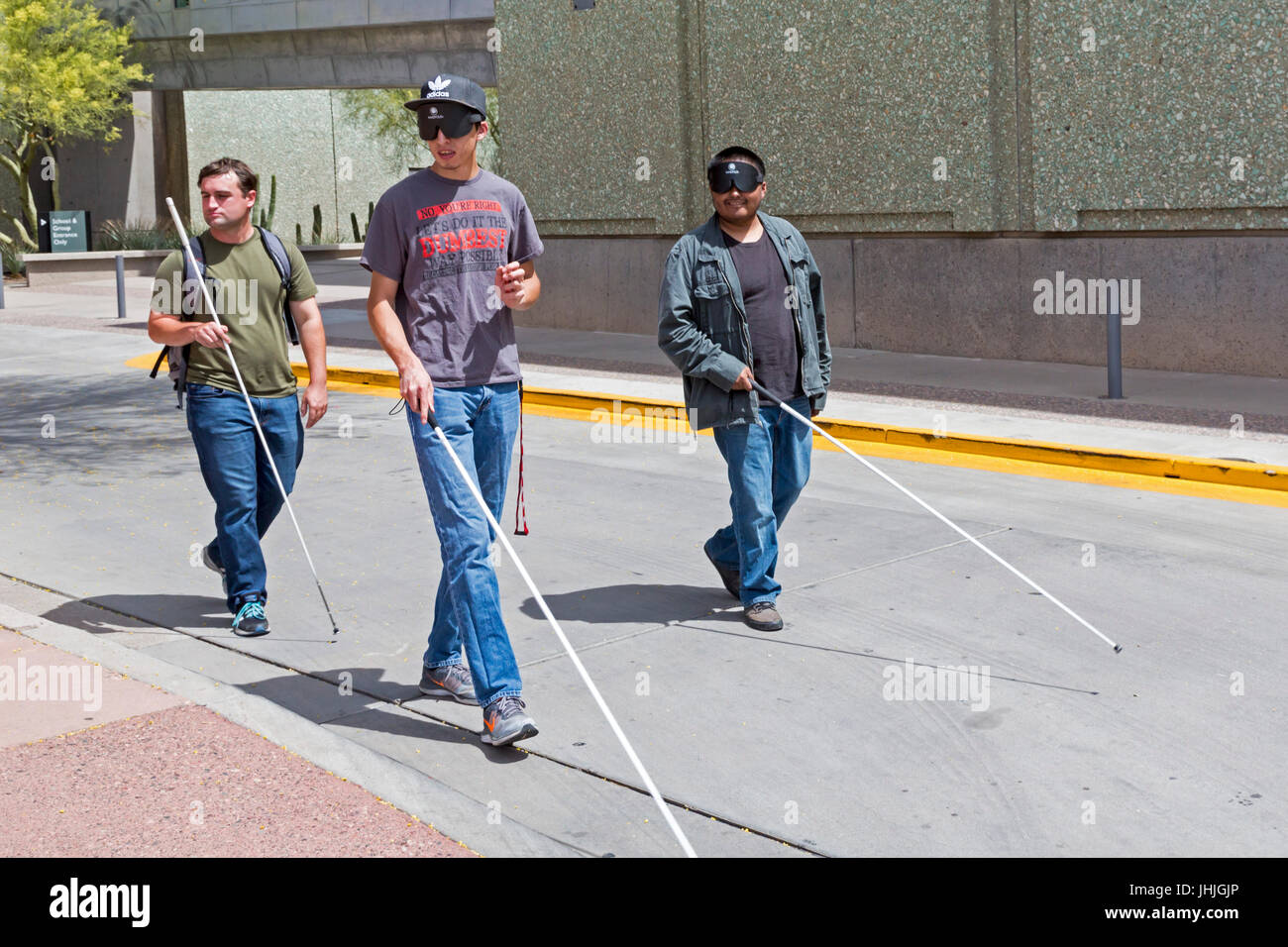 Phoenix, Arizona - aveugles et malvoyants, certains jeunes hommes portant des masques de sommeil, pratique la navigation dans les rues de la ville avec une canne blanche. Banque D'Images