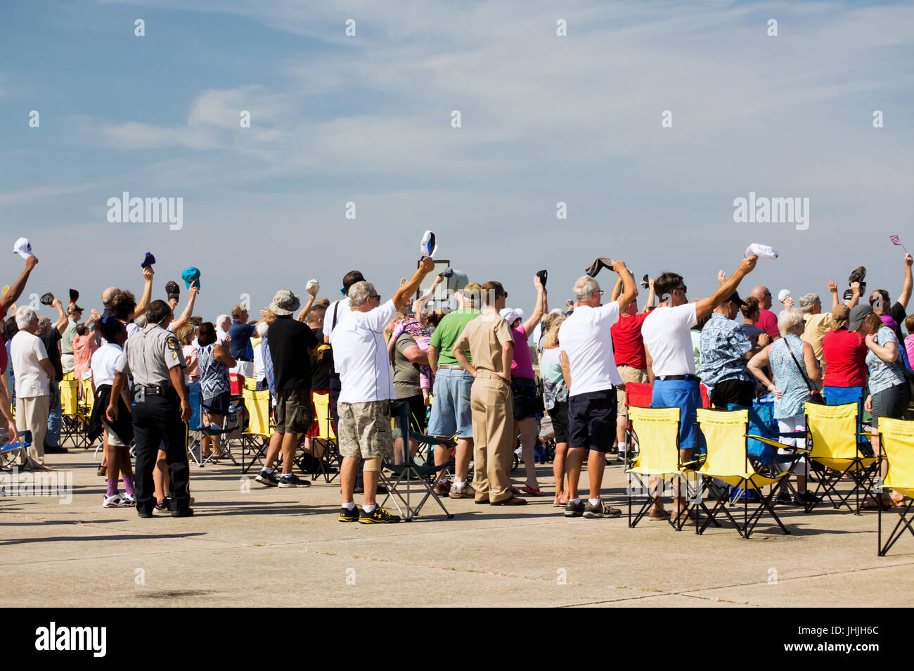 Une foule qui soulève des chapeaux à un spectacle aérien. Banque D'Images