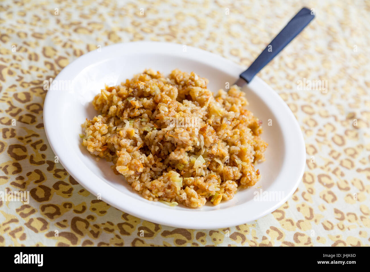 Vegan fait maison avec du riz frit de carottes, de choux et de la sauce soja sur plaque blanche, prêt à manger. Close up Banque D'Images