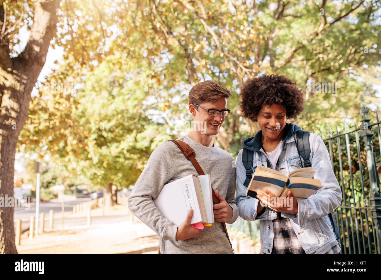 Les étudiants de l'université reading book dans la cour du collège. Les jeunes élèves du collège avec des livres sur la rue. Banque D'Images