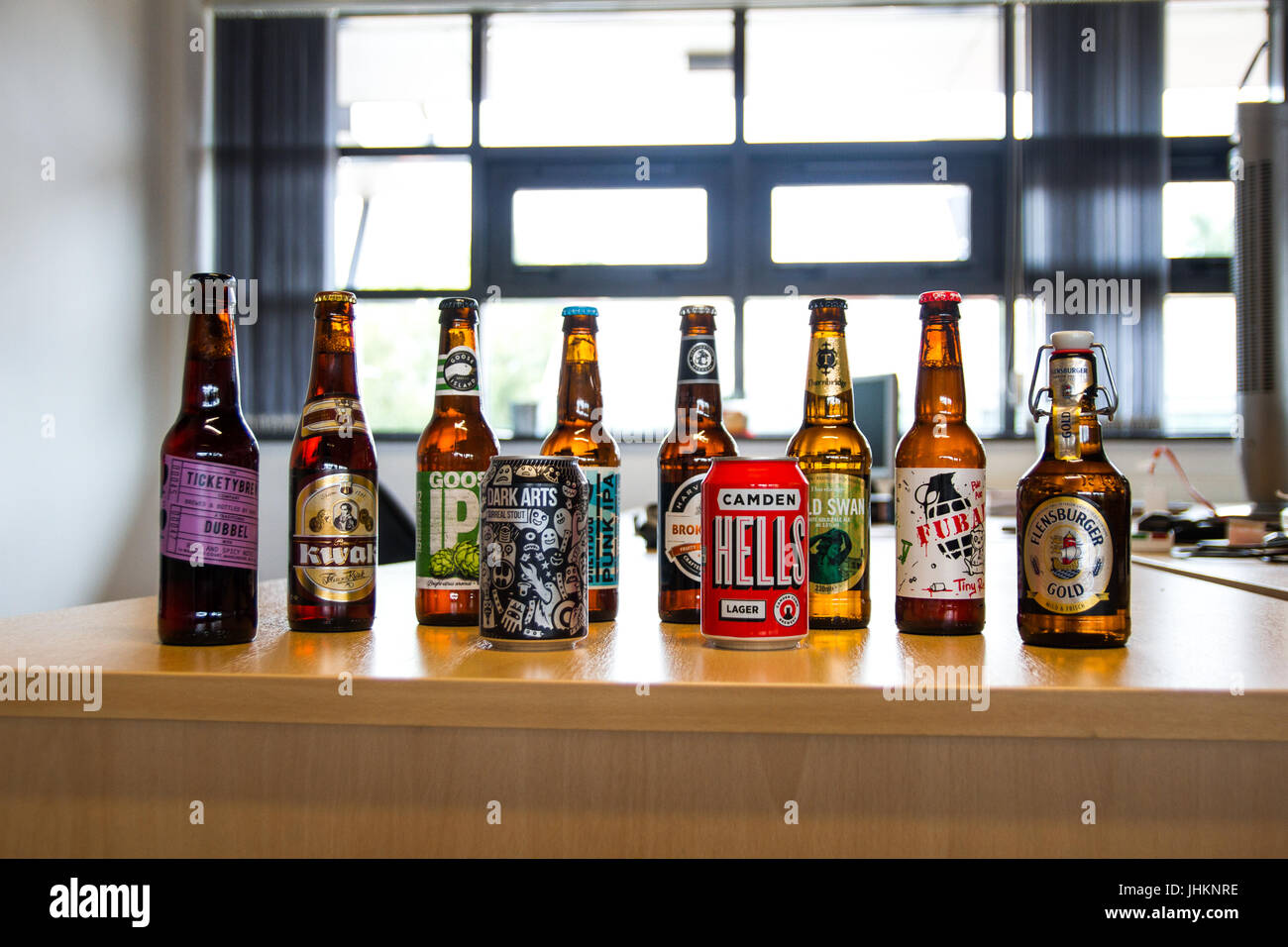 Une sélection de bières assis sur un bureau avec une lumière qui brille dans l'arrière-plan. Banque D'Images