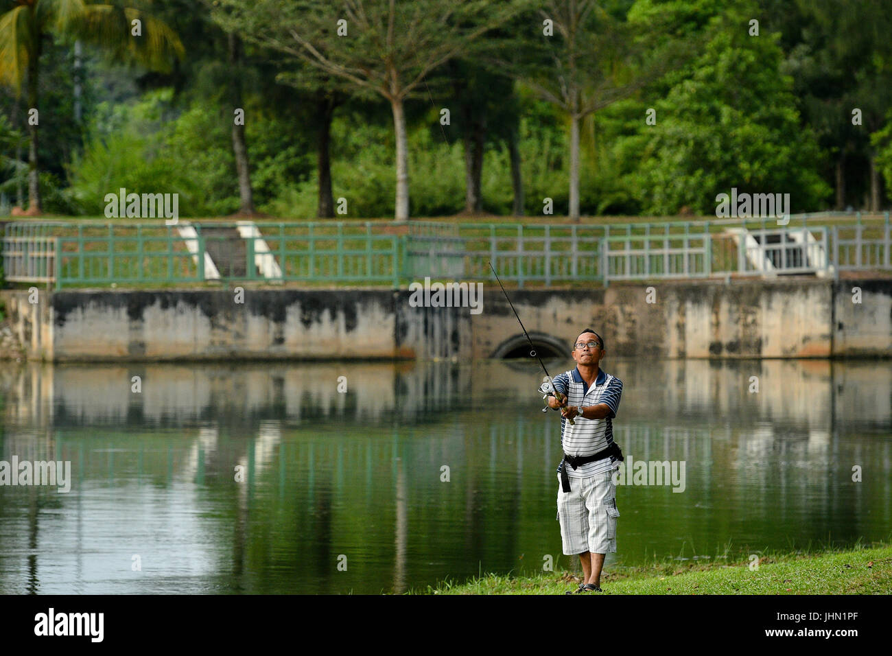 Un homme à la pêche dans le magnifique lac à Sepang, Negeri Sembilan Banque D'Images