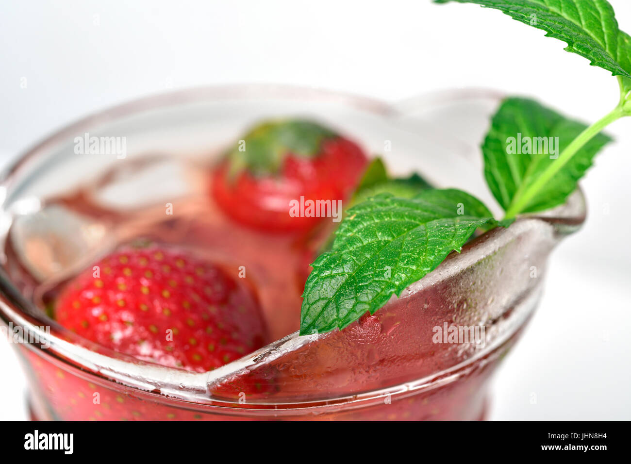 Libre d'un pichet de verre avec sangria espagnol typique, avec quelques morceaux de fruits frais sur un fond blanc Banque D'Images