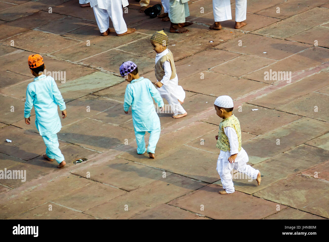 Les enfants jouent dans la masse musulmane de la mosquée Jama Masjid à l'occasion de l'Aïd. Banque D'Images