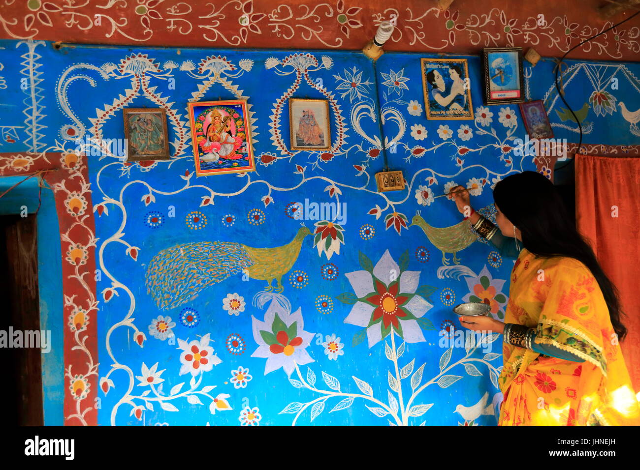 Une femme attire les motifs traditionnels sur un mur de sa maison Tikoil Nachole au village de l'upazila de district de Chapainawabganj Bangladesh. Plus de cinquième Banque D'Images