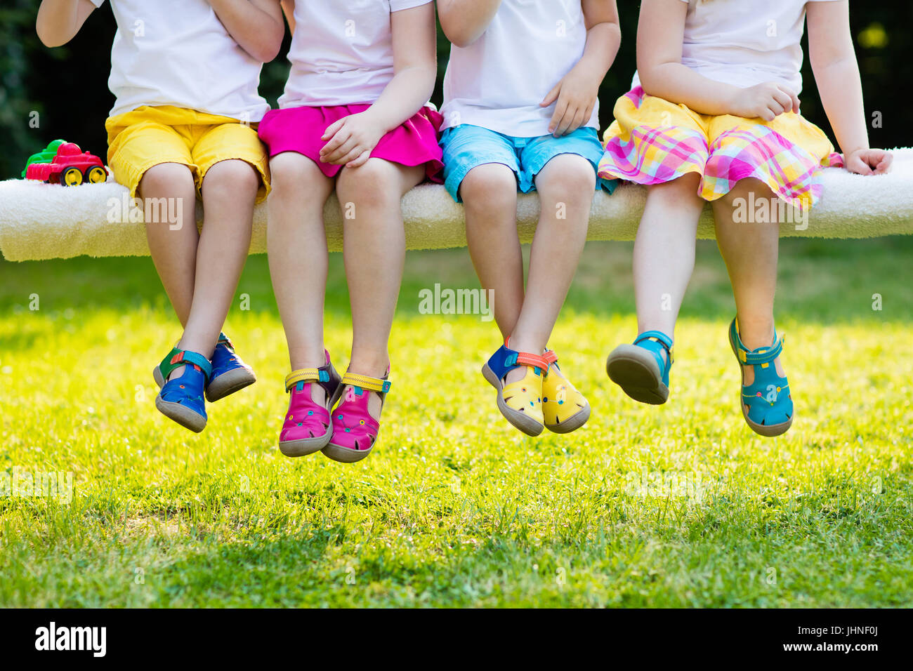 Les chaussures pour enfants. Groupe d'enfants d'âge préscolaire portant des chaussures en cuir coloré. Chaussures d'été sandales pour jeune enfant et bébé. Bambin jouer pis Banque D'Images