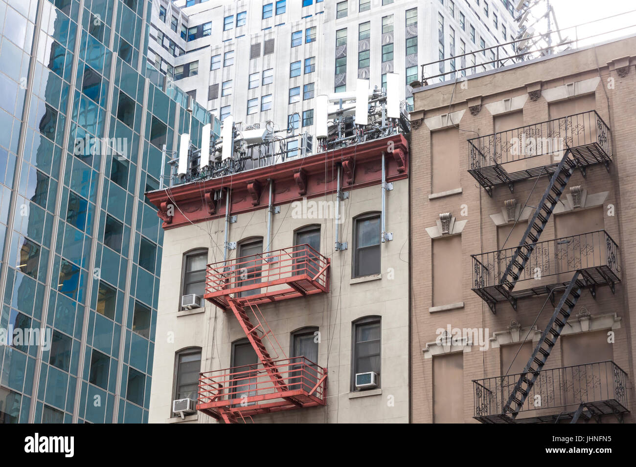 Les antennes de téléphonie cellulaire de faible hauteur sur un appartement d'angle sur le toit du bâtiment dans midtown east, New York, NY, États-Unis Banque D'Images