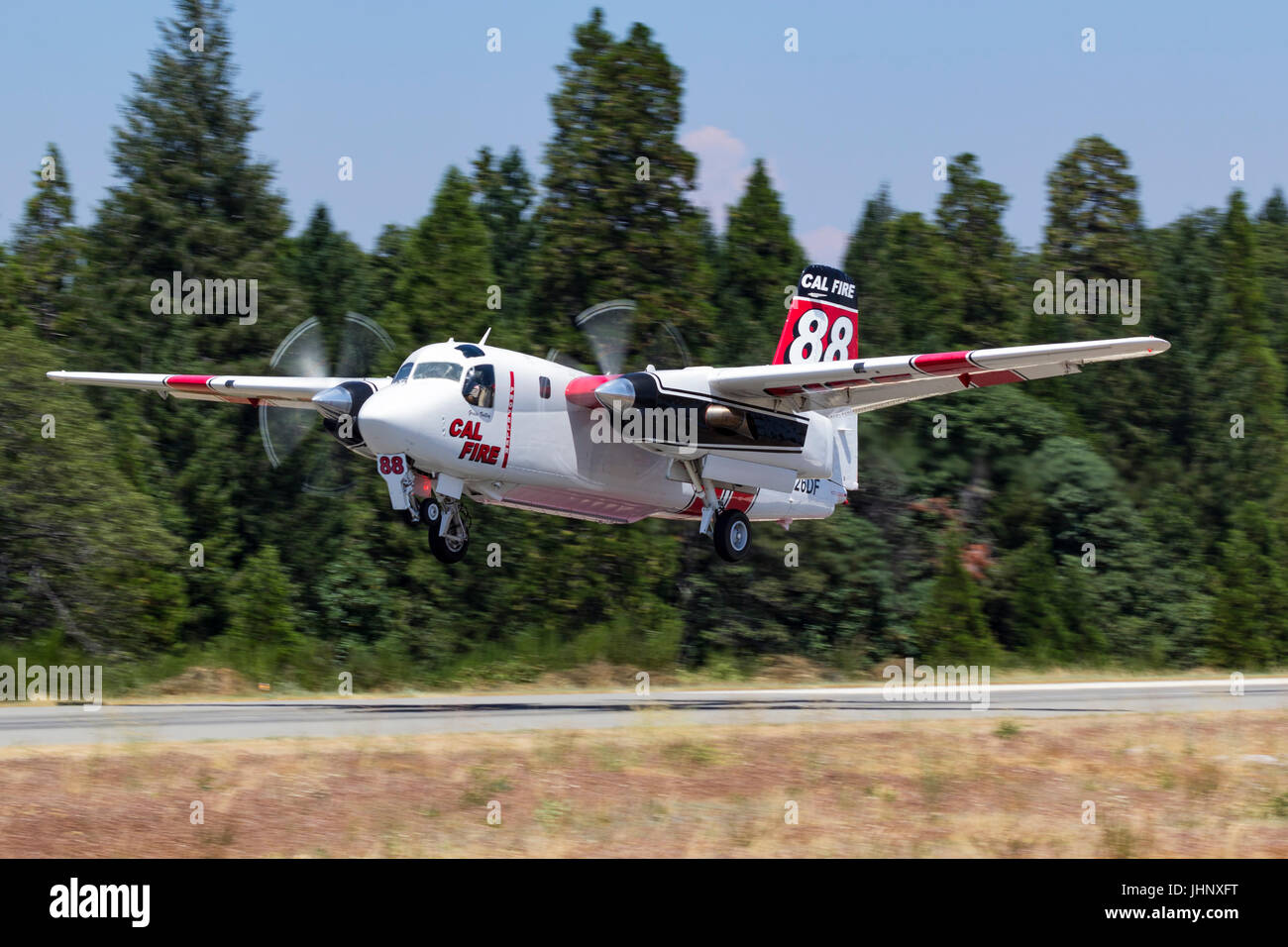S-2F3À Tracker, la FDC 88, obtient de l'herbe en suspension dans l'air de la vallée de la base d'attaque dans le Nord de la Californie en route vers une forêt. Banque D'Images