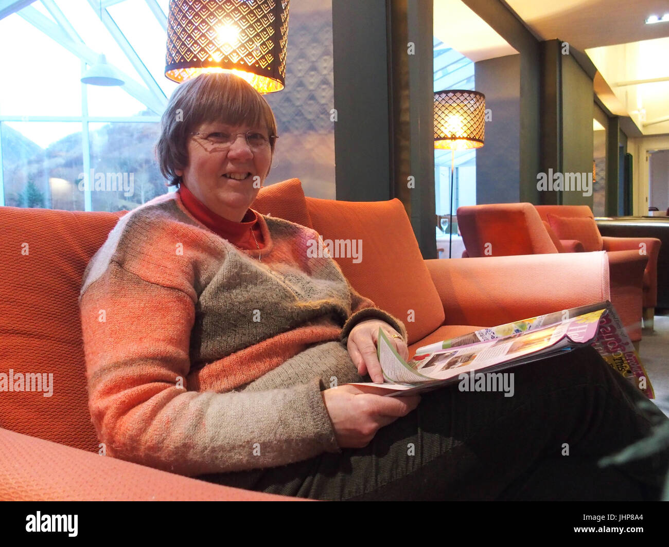 Woman Reading magazine dans un hôtel Banque D'Images