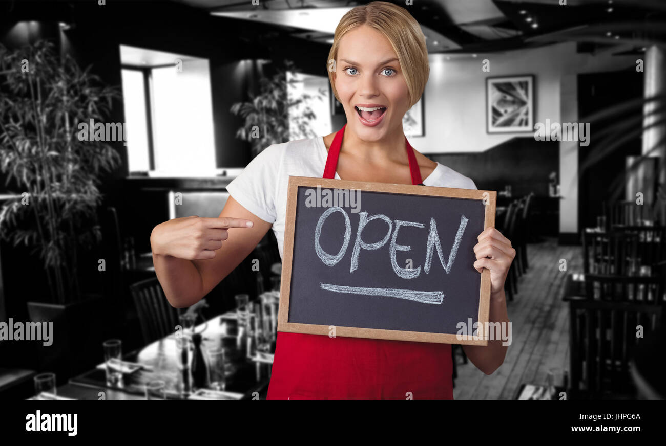 Portrait of happy woman holding écrit slate avec open text contre l'intérieur de restaurant Banque D'Images