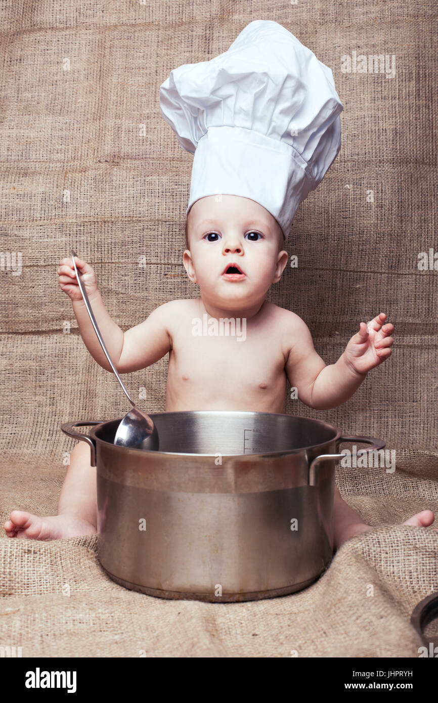 Petite fille dans une hotte de cuisine. Elle décroche à l'aide d'une louche  de la casserole Photo Stock - Alamy