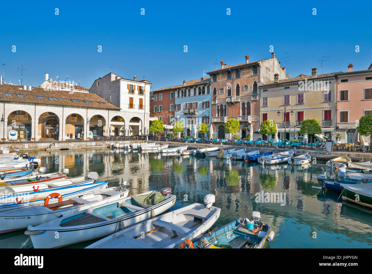 Italie LAC DE GARDE DESENZANO DEL GARDA DÉBUT MORNINGTHE PORT AVEC BATEAUX ET RESTAURANTS ALENTOURS EN AVRIL Banque D'Images