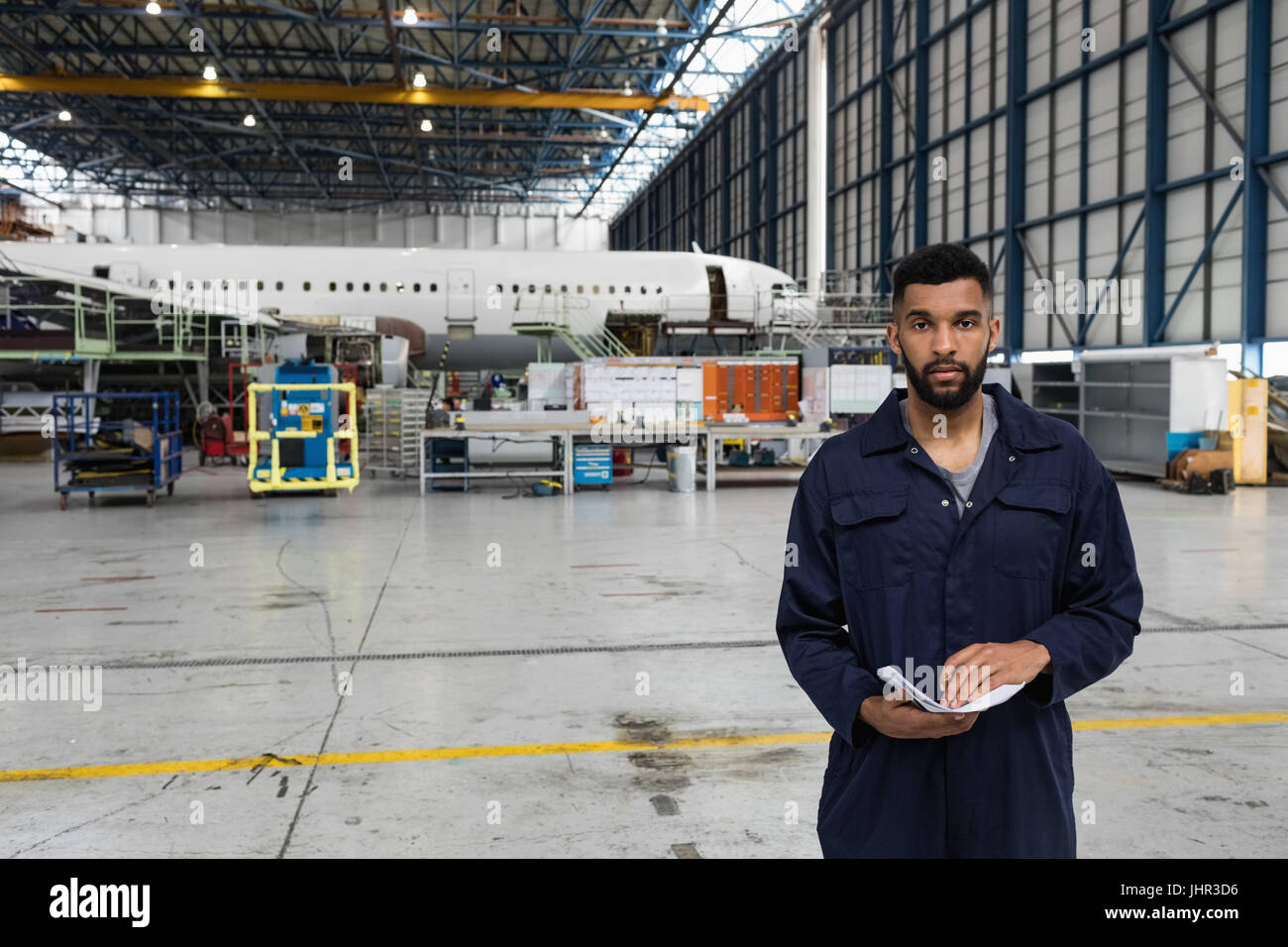 Portrait de technicien d'entretien d'aéronef debout à l'installation de maintenance des compagnies aériennes Banque D'Images