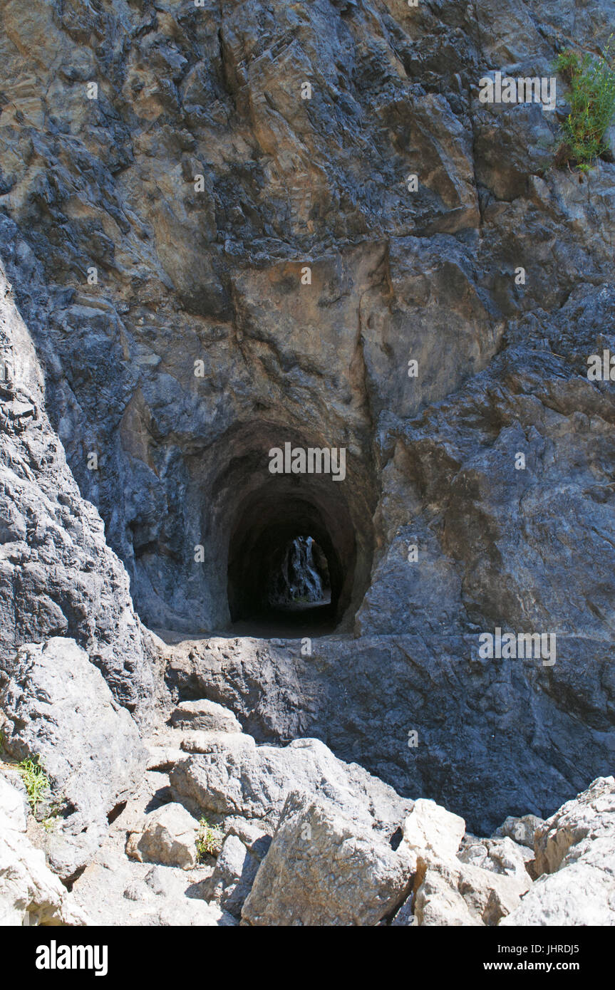 Italie : tunnel creusé dans la roche qui mène à la plage cachée, Arco Magno little bay avec une arche naturelle faite par les vagues au cours des siècles Banque D'Images