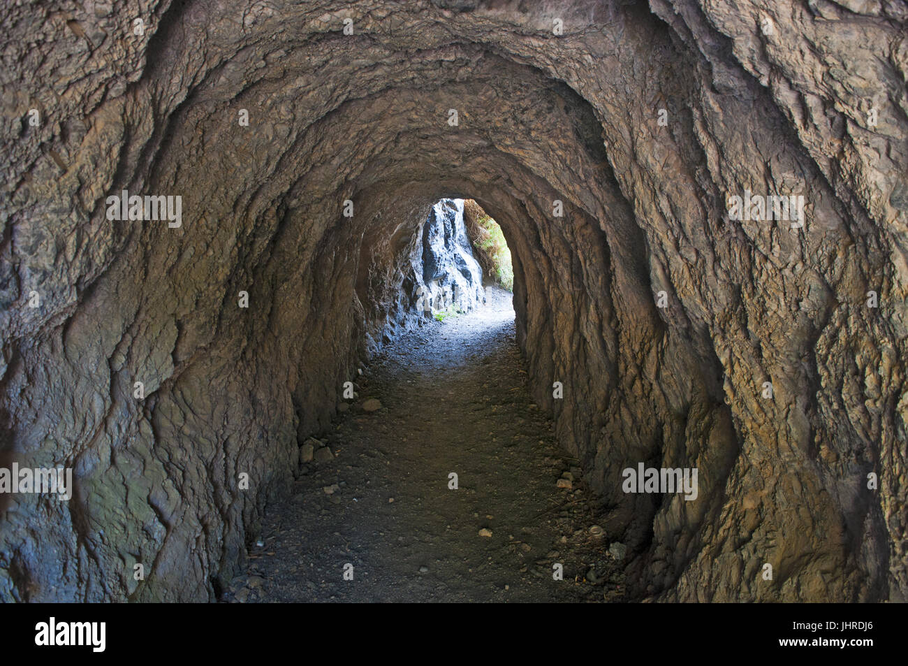 Italie : tunnel creusé dans la roche qui mène à la plage cachée, Arco Magno little bay avec une arche naturelle faite par les vagues au cours des siècles Banque D'Images