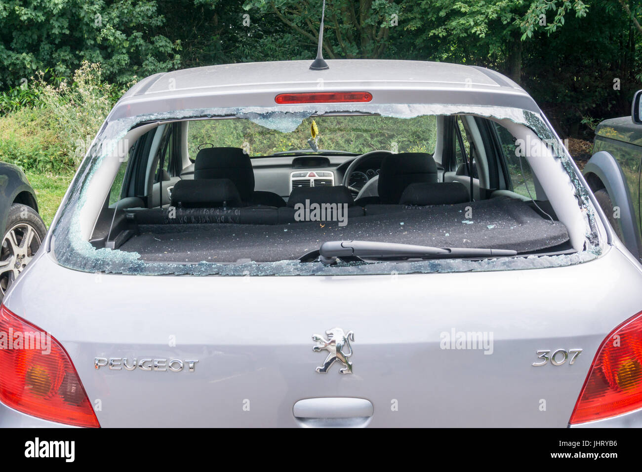 La fenêtre arrière cassée d'une voiture dans un parking. Banque D'Images