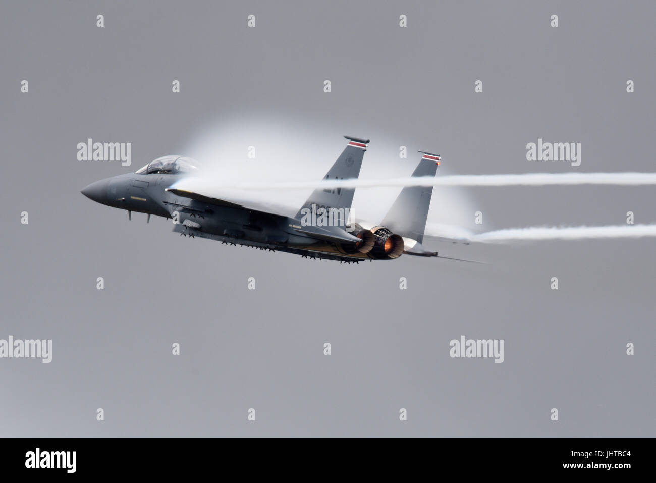 Avion de chasse McDonnell Douglas Boeing F-15 Eagle de la RAF Lakenheath effectuant une démonstration de force à grande vitesse lors d'un spectacle aérien créant un nuage d'humidité à partir de la pression de l'air comprimé Banque D'Images