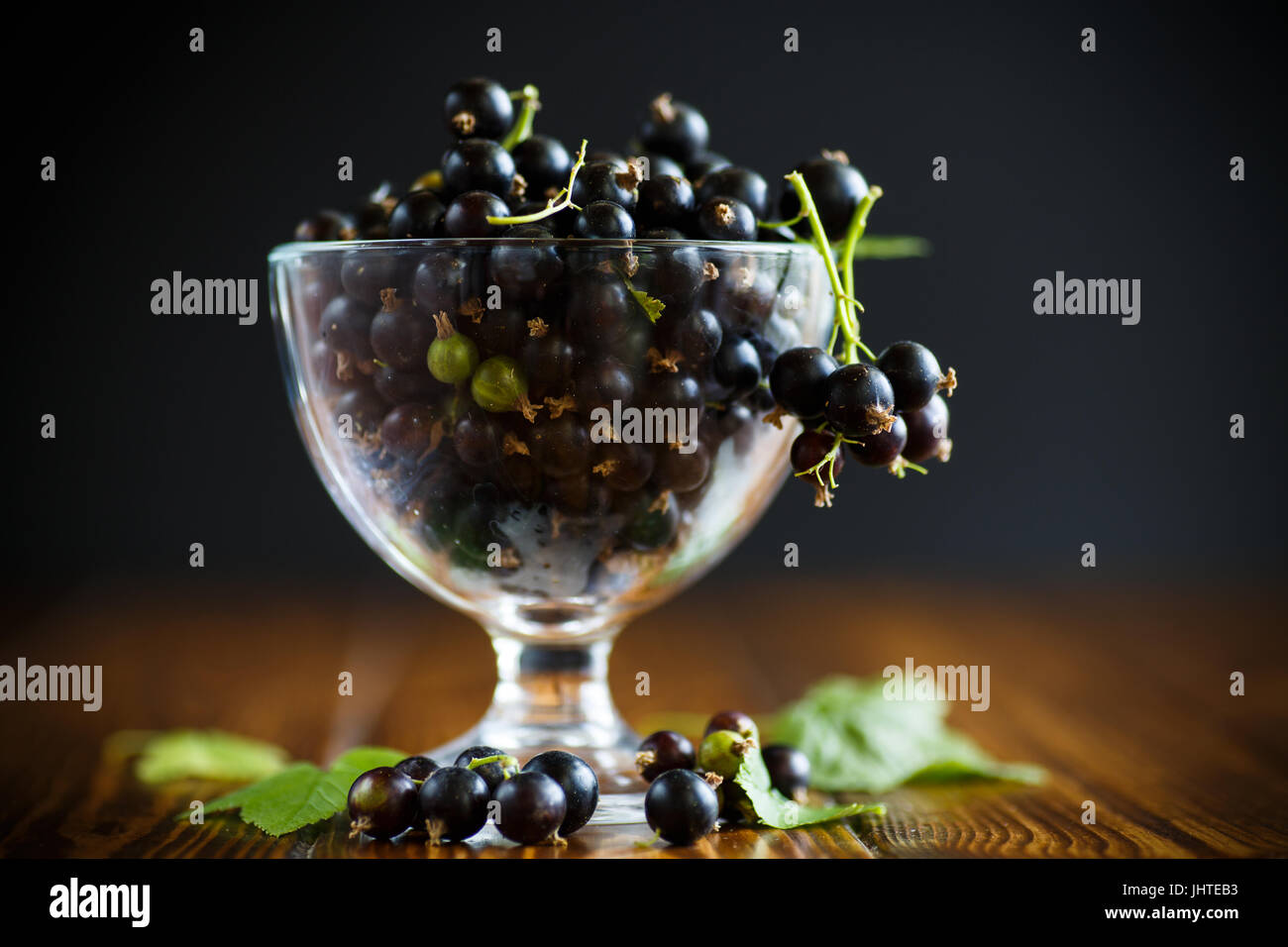 Le cassis dans un bol en verre sur une table en bois Banque D'Images