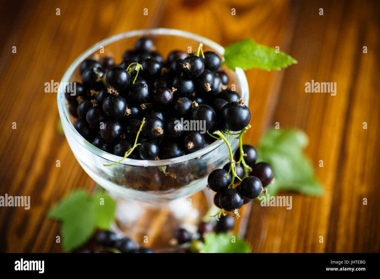 Le cassis dans un bol en verre sur une table en bois Banque D'Images