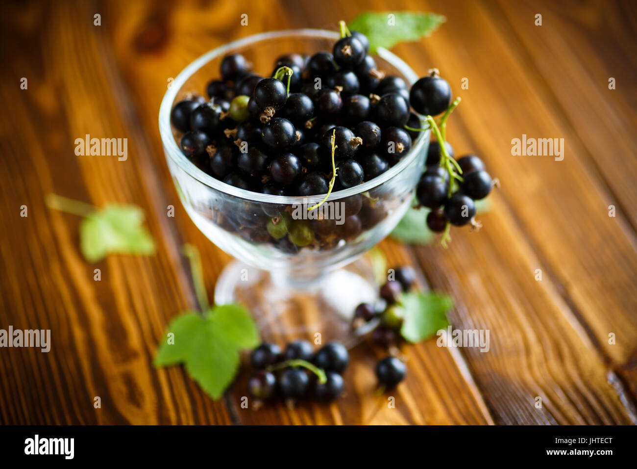 Le cassis dans un bol en verre sur une table en bois Banque D'Images