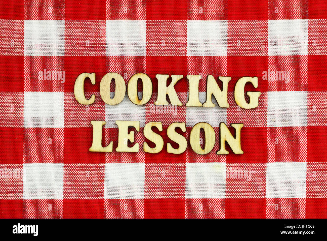 Leçon de cuisine en bois avec écrit les lettres sur le tissu à carreaux rouge et blanc Banque D'Images
