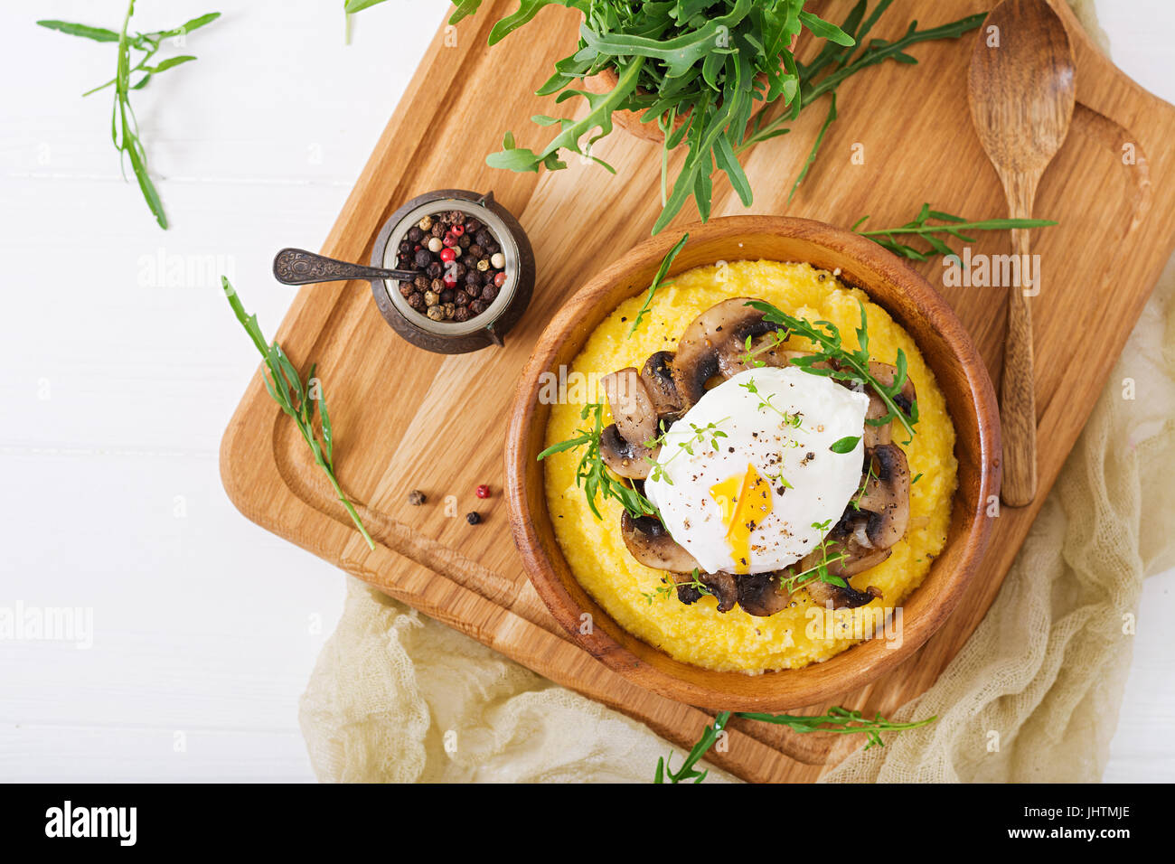 Le petit-déjeuner. La polenta aux champignons et œuf poché. Mise à plat. Vue d'en haut. Banque D'Images