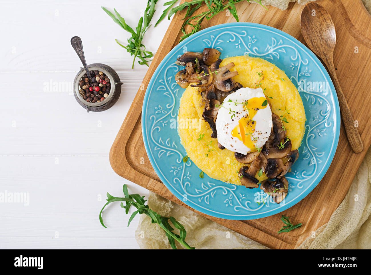 Le petit-déjeuner. La polenta aux champignons et œuf poché. Mise à plat. Vue d'en haut. Banque D'Images