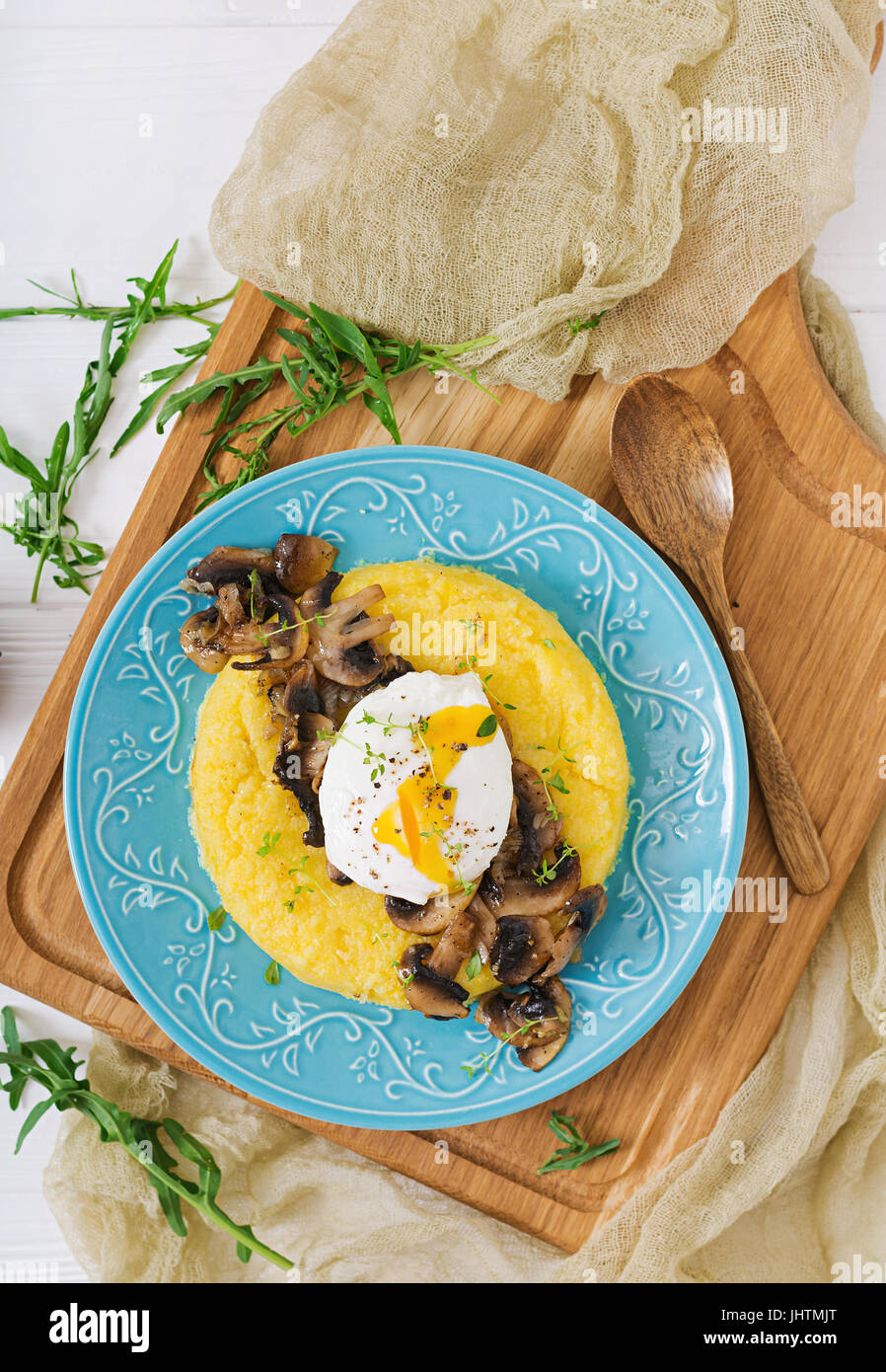 Le petit-déjeuner. La polenta aux champignons et œuf poché. Mise à plat. Vue d'en haut. Banque D'Images