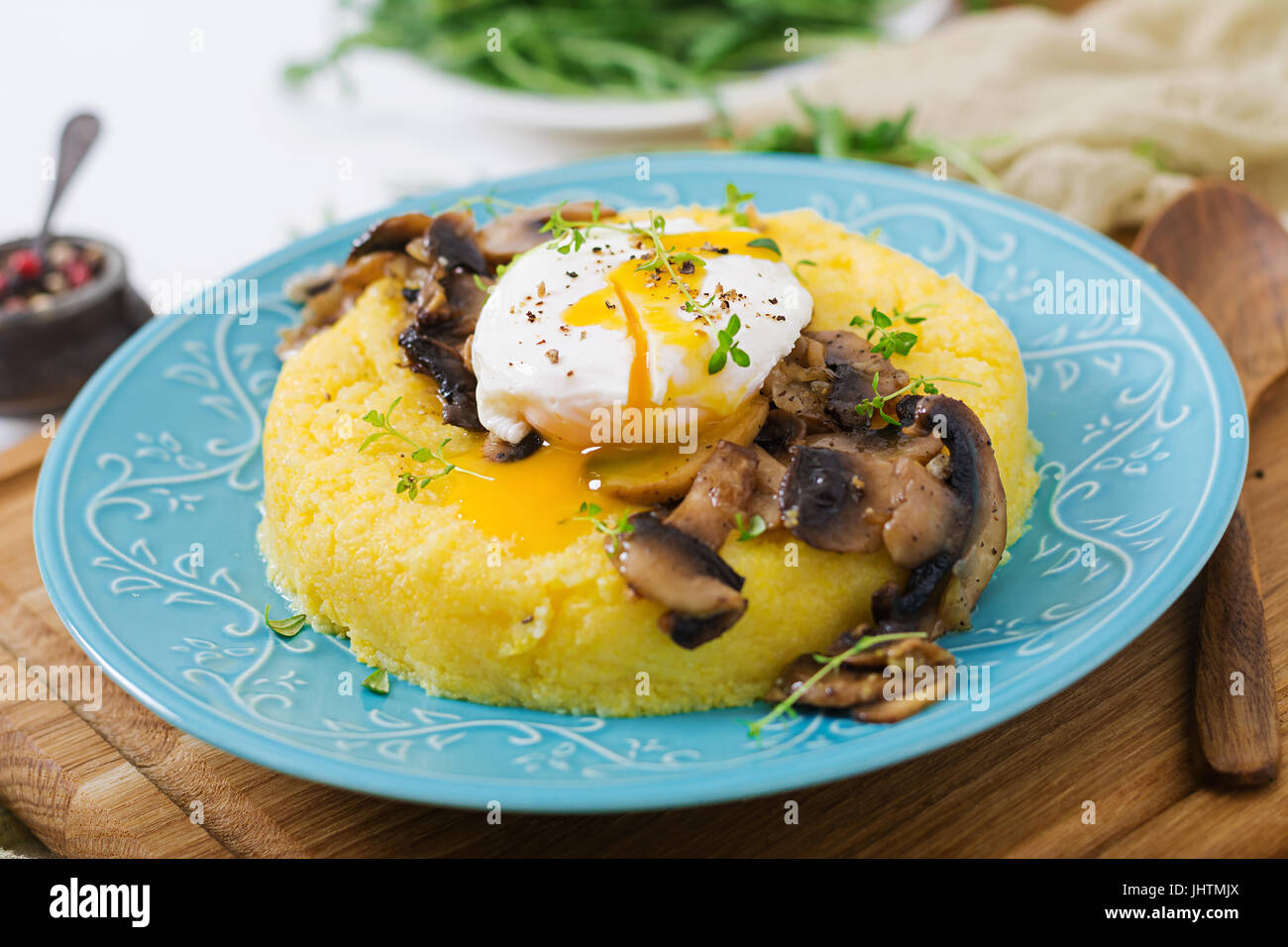 Le petit-déjeuner. La polenta aux champignons et œuf poché. Banque D'Images