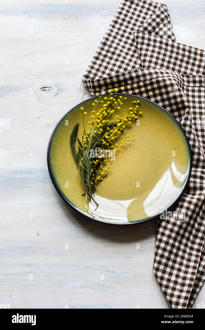 Table de fête pour un dîner de Pâques avec des œufs de pâques et mimosa sur plaque rustique Banque D'Images