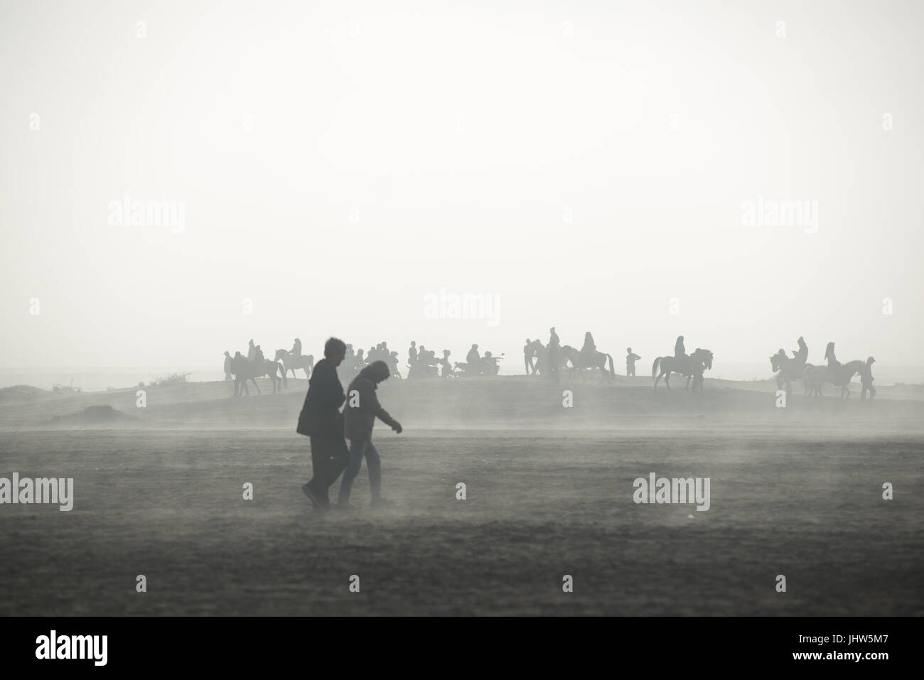 Les Indonésiens l'équitation dans une mer de sable dans le Mont Bromo est de Java en Indonésie. Banque D'Images