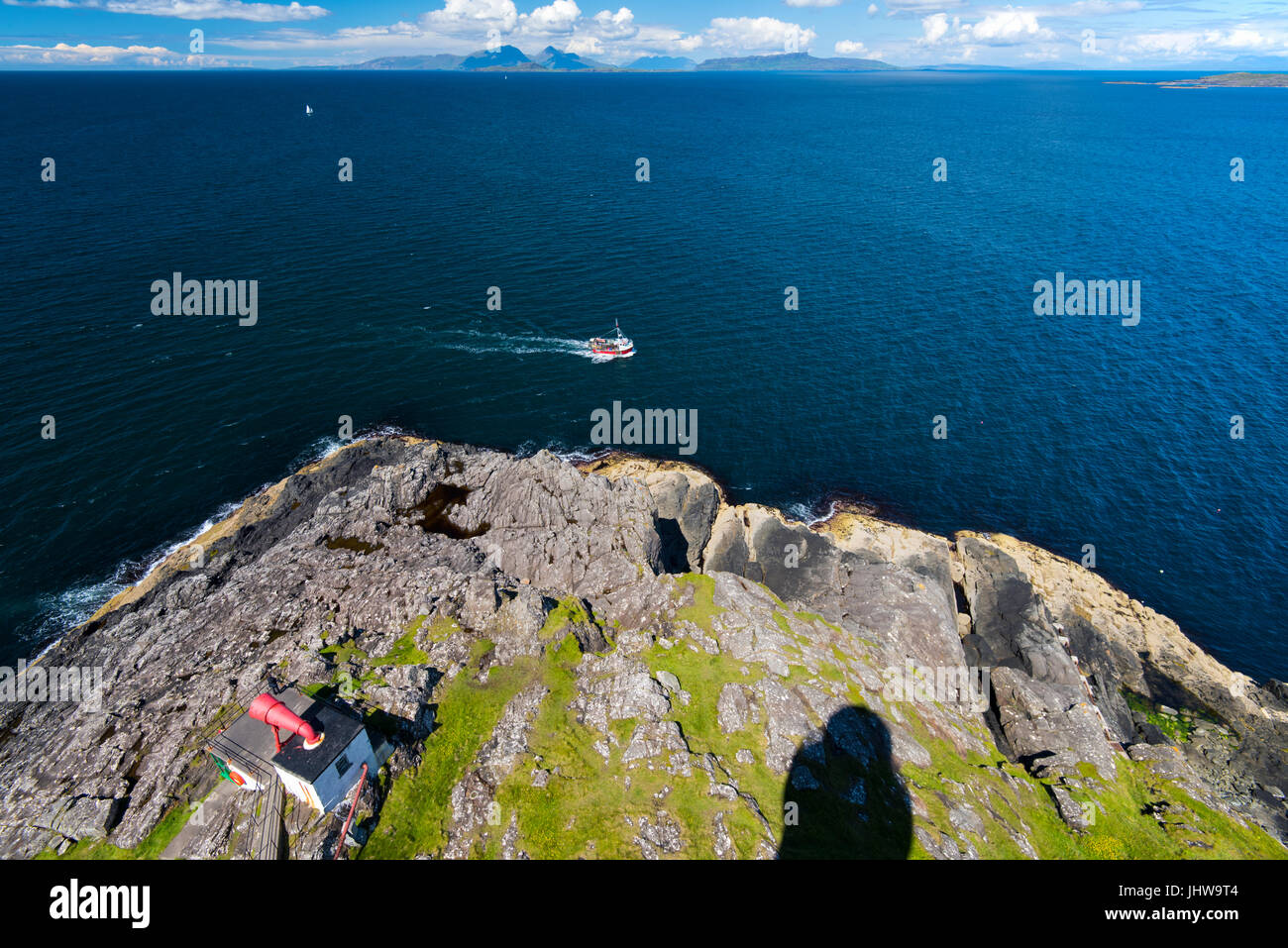 Bateau de pêche bateau à passé 38 withfoghorn point visible à gauche et le rhum, Eigg, Muck et Skye à l'arrière-plan vu du haut du phare Banque D'Images