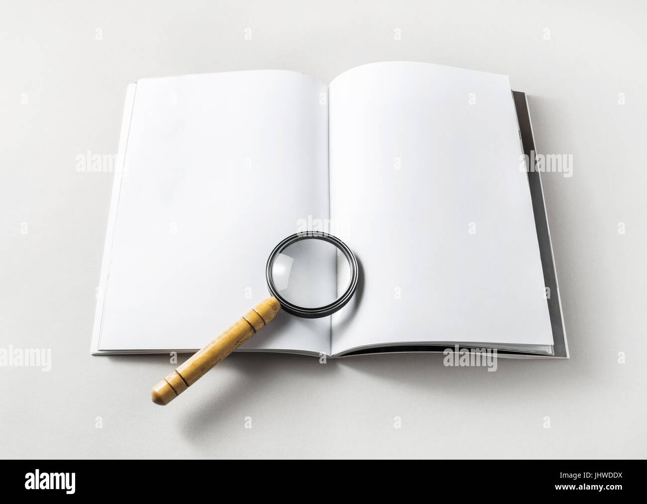 Livre blanc ouvert et la loupe sur le papier de fond. Modèle pour placer votre conception. Responsive design immersive. Banque D'Images