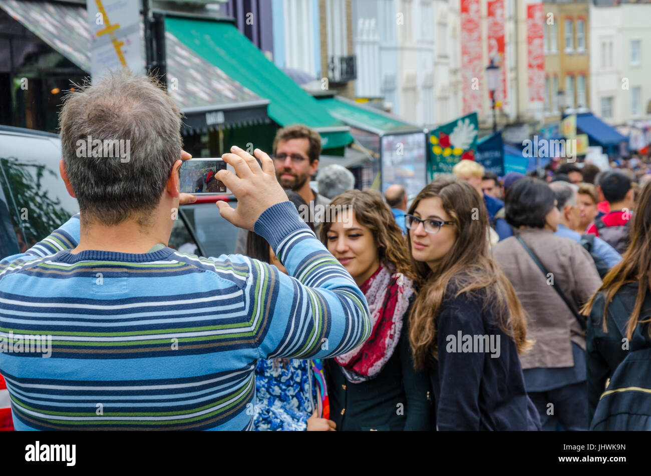 Une famille posent pour une prise selfies sur un téléphone mobile sur Portobello Road à Notting Hill, Londres. Banque D'Images