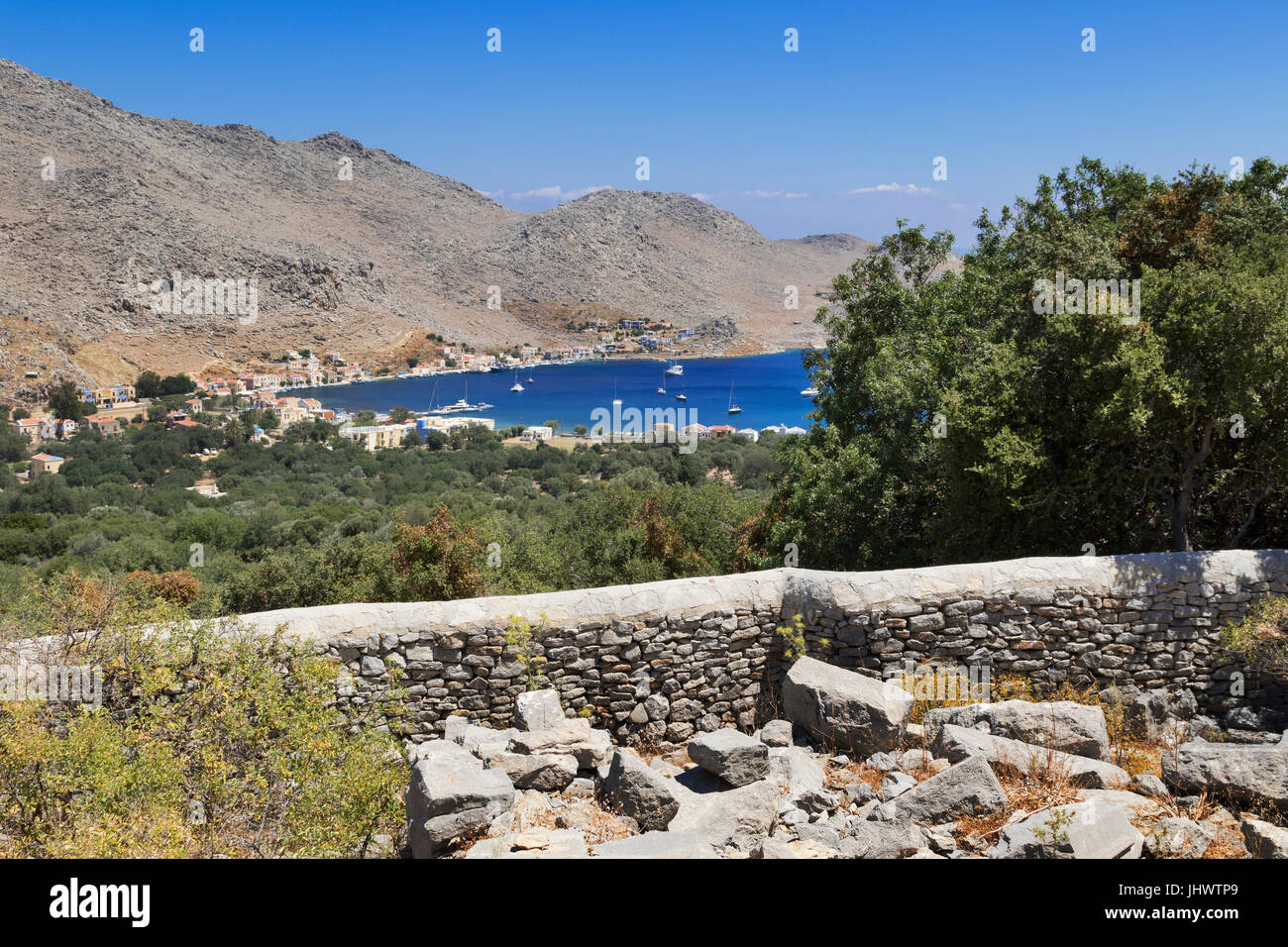 L'île de Symi, sud de la mer Egée, Grèce - la vue de la baie de Pedi Drakos, les vestiges d'une ancienne fortification dans les collines Banque D'Images