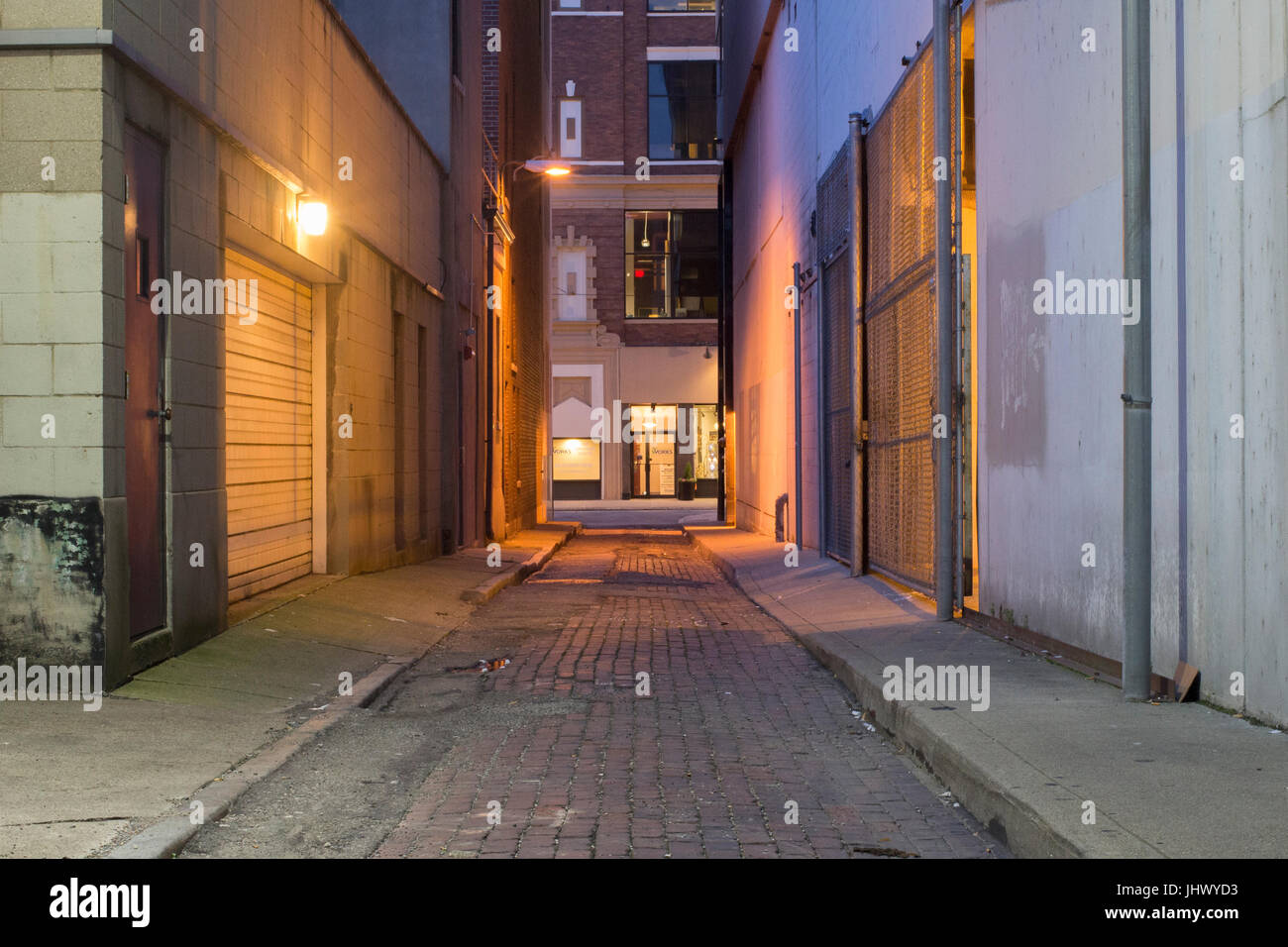 Ville sombre ruelle de feux et d'une rue pavée. Banque D'Images