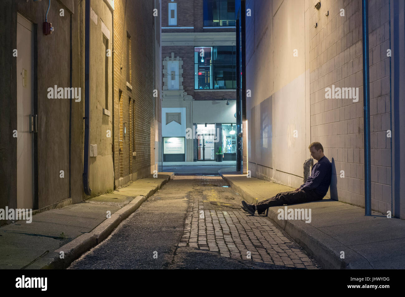 L'homme dans une ruelle sombre semble être ivre, perdu ou a besoin d'aide. Banque D'Images