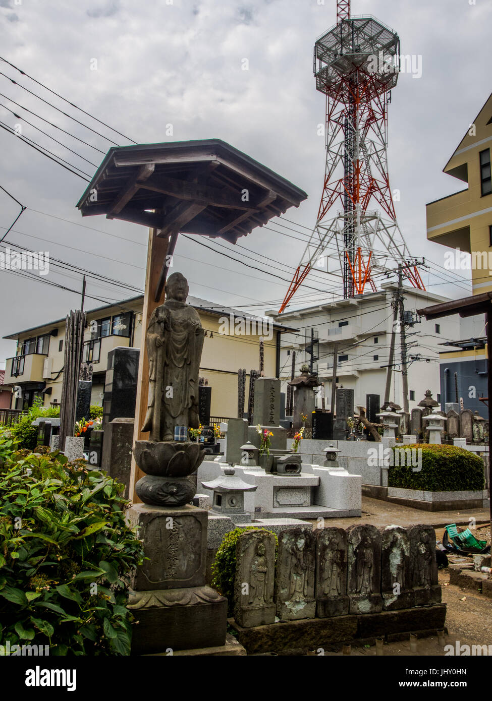 Statue sacrée bouddhiste avec tour de communication et les immeubles à appartements, Nishi Ward, Omiya, Saitama. Banque D'Images