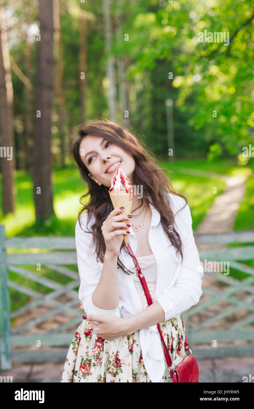 Gros plan extérieur fashion portrait of young girl crazy hipster la consommation de crème glacée en été par temps chaud s'amuser et de bonne humeur. Style tons instagram filt Banque D'Images