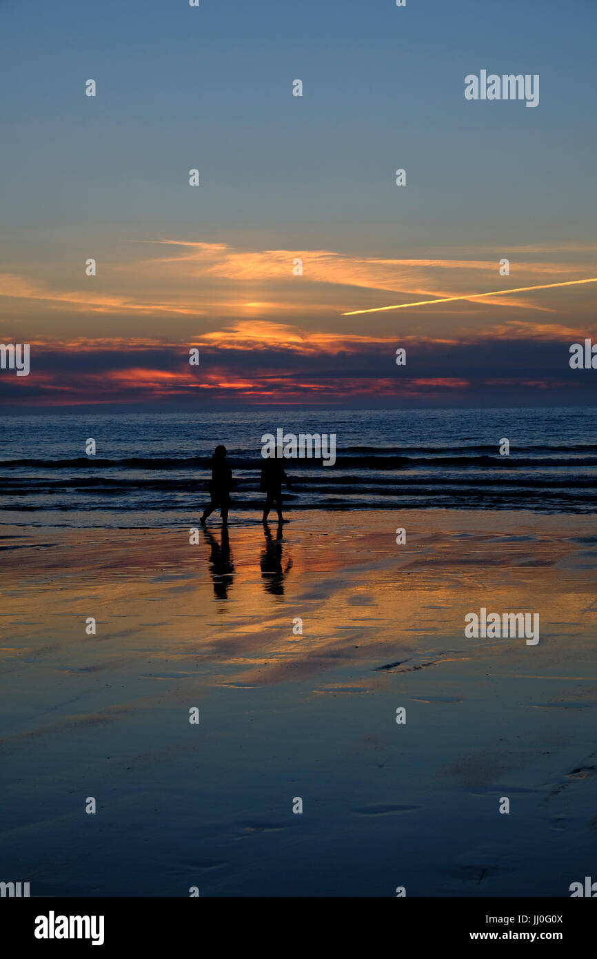 Couple en train de marcher sur la plage de Newquay en Cornouailles Banque D'Images