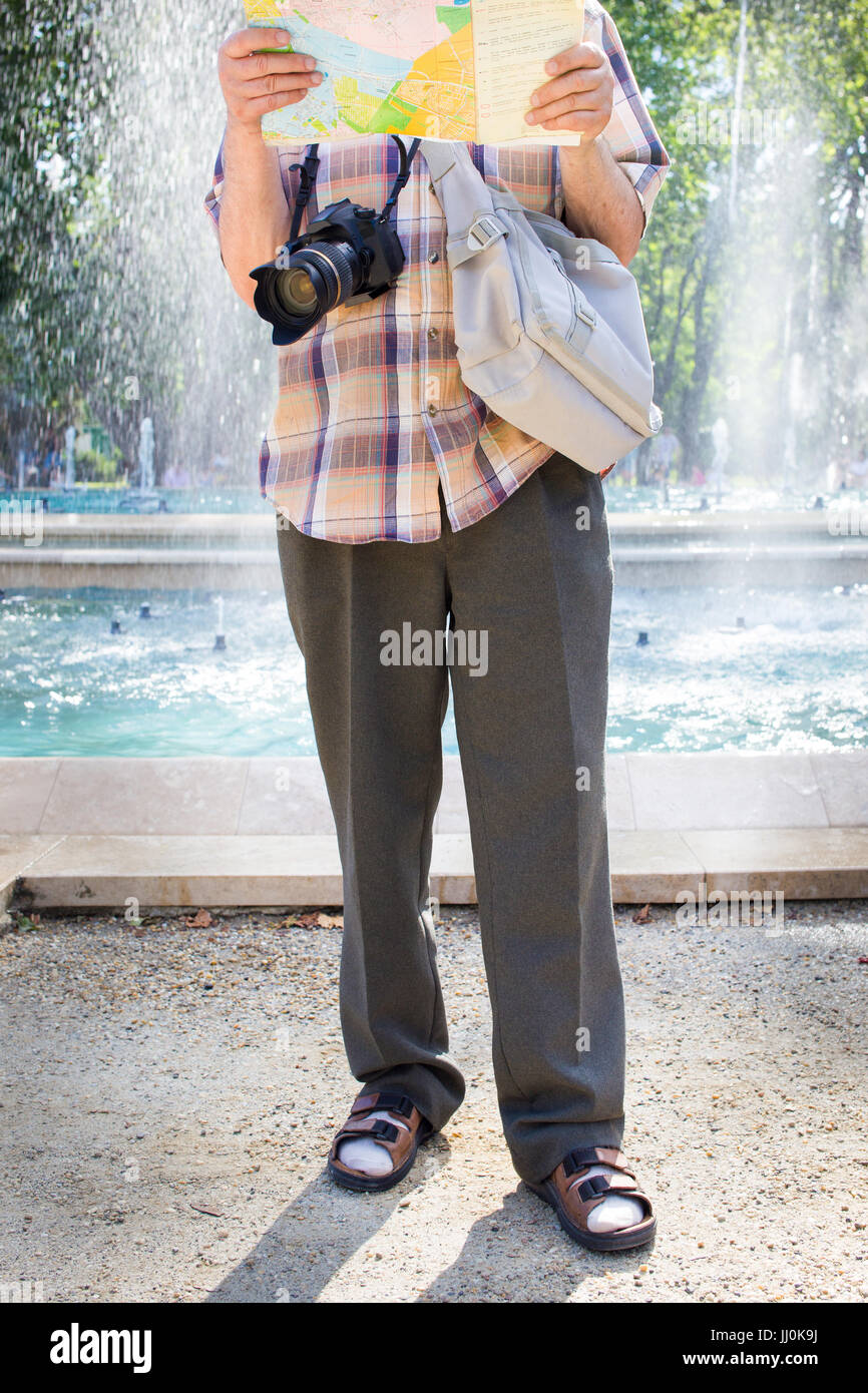 Tourisme Senior man with camera et carte des chaussettes et sandales Banque D'Images