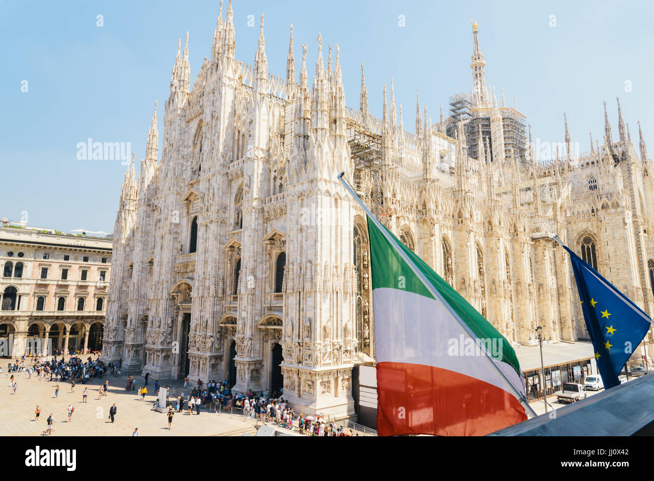 Et l'Union européenne drapeau italien sur le premier plan et la Piazza Duomo, Milan sur une journée ensoleillée Banque D'Images