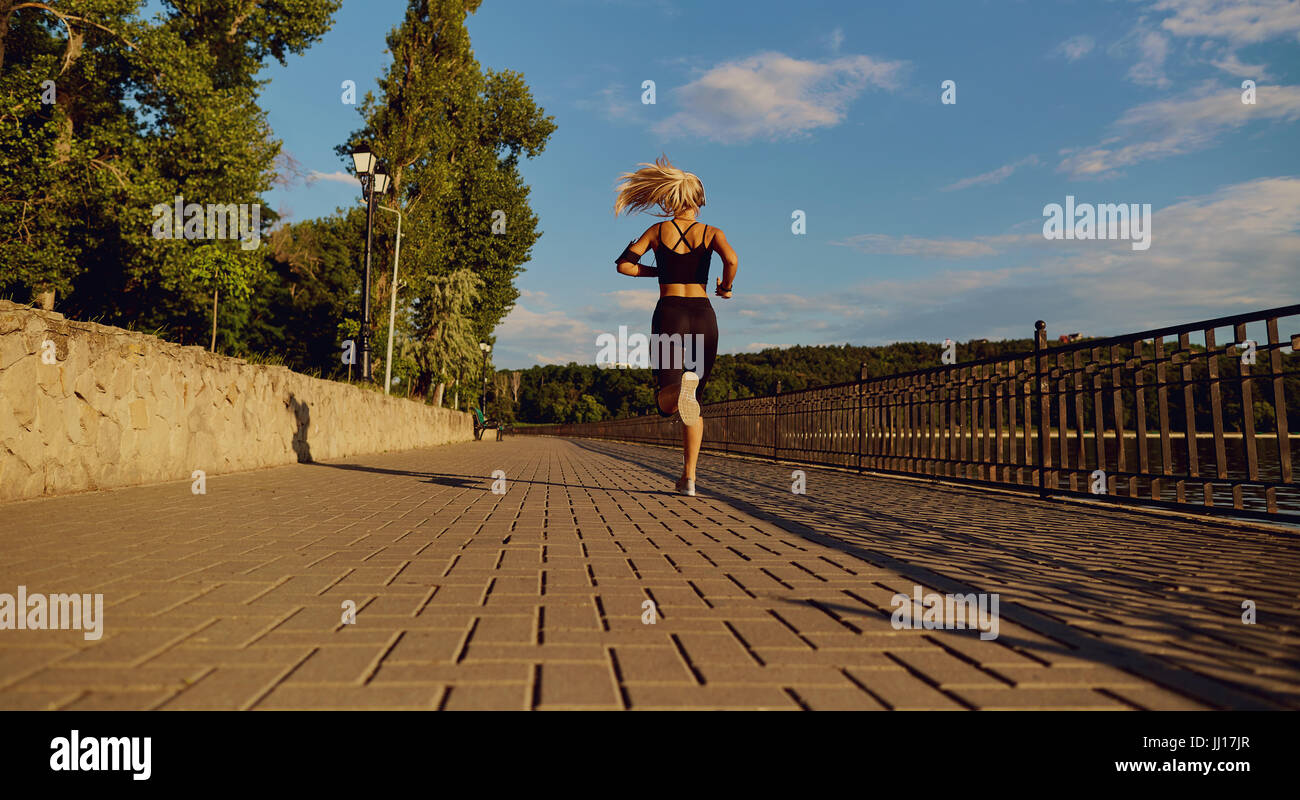 Girl runner jogging dans le parc sur route Banque D'Images