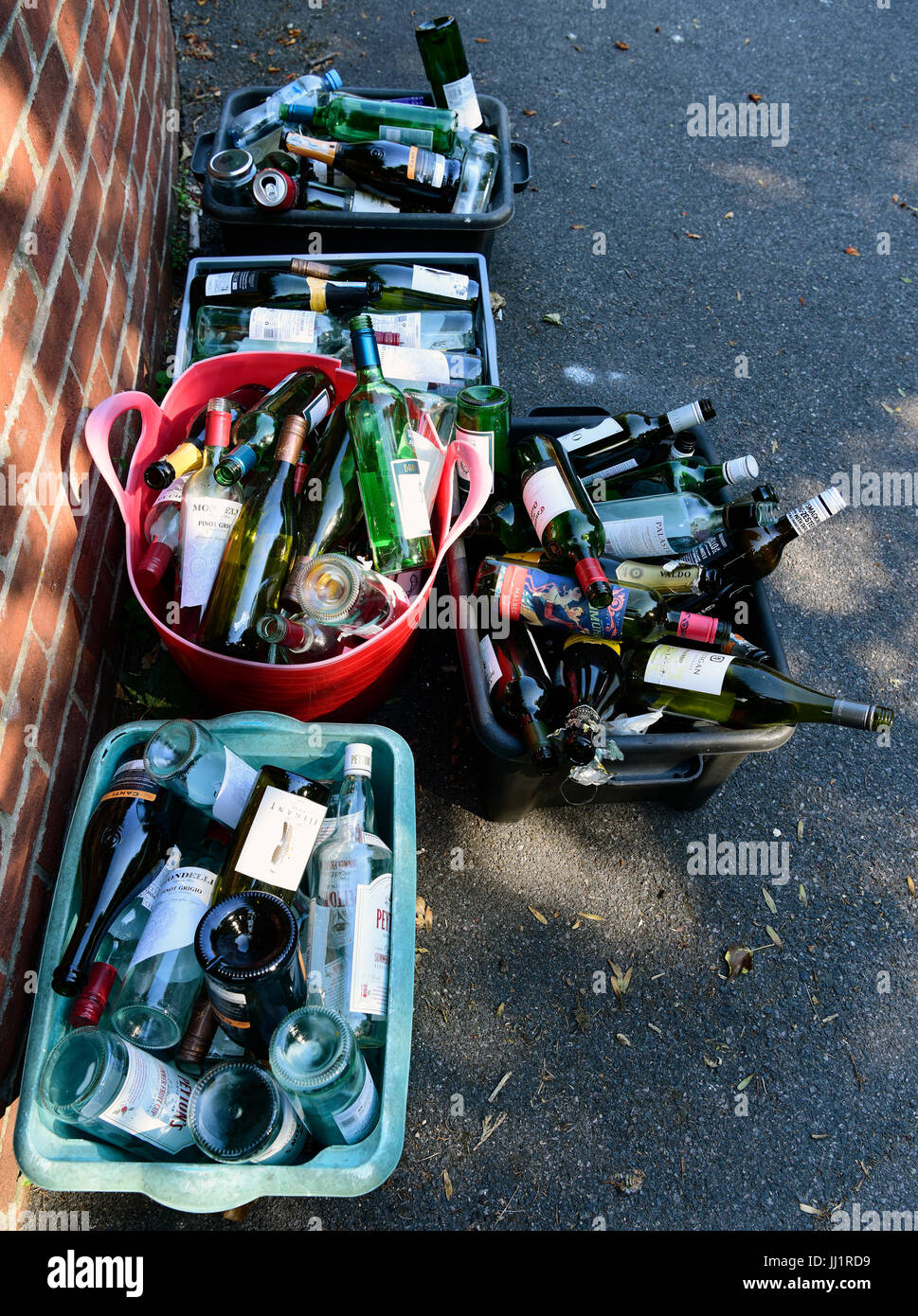 Bouteilles en verre placé dans les boîtes de recyclage à l'extérieur de la propriété par le conseil collection éboueurs dans le village de Selborne, Hampshire, Royaume-Uni. Banque D'Images